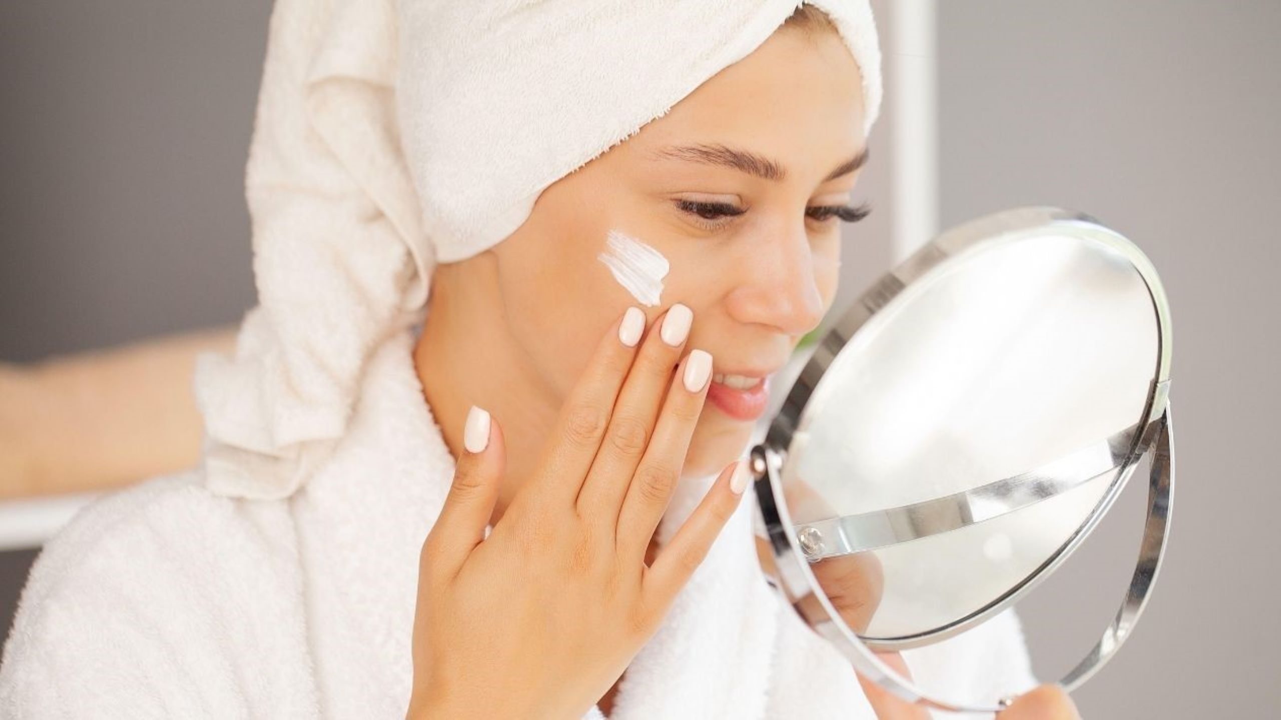 Woman applying hydrating moisturizer for winter skincare routine addressing Morocco's dry climate challenges, demonstrating proper barrier protection and hyaluronic acid application for desert conditions