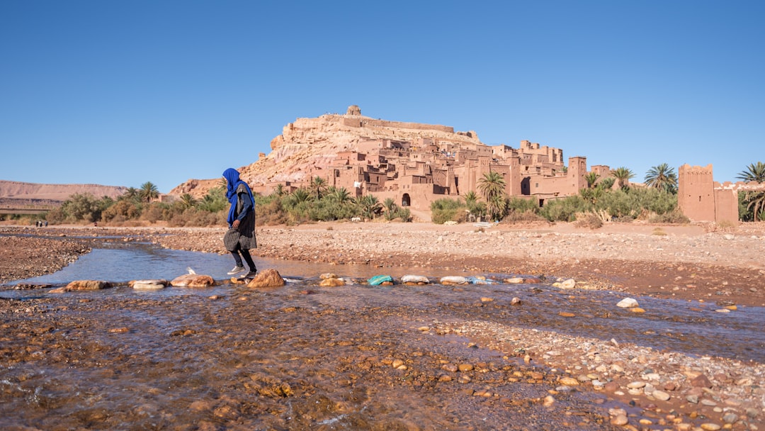 trekker walks in Berber village in the Moroccan mountain of the High Atlas, surrounded by terraced fields and walnut trees.