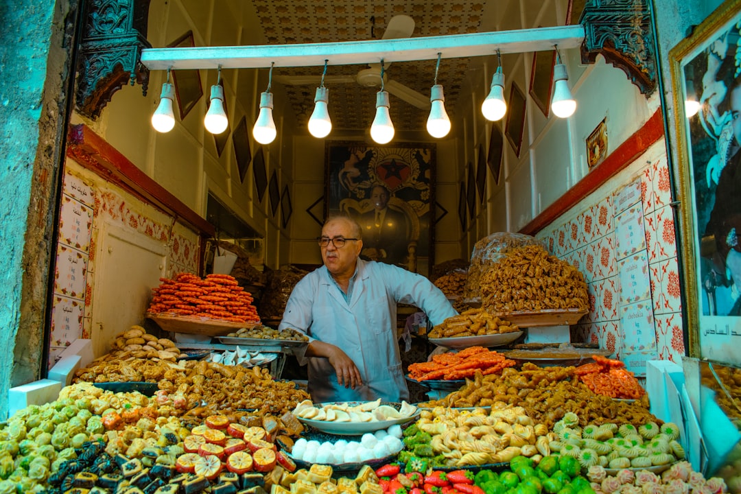 A woman choosing Moroccan street food at a busy medina stall, a scene that captures the daily joy of eating safely in Morocco