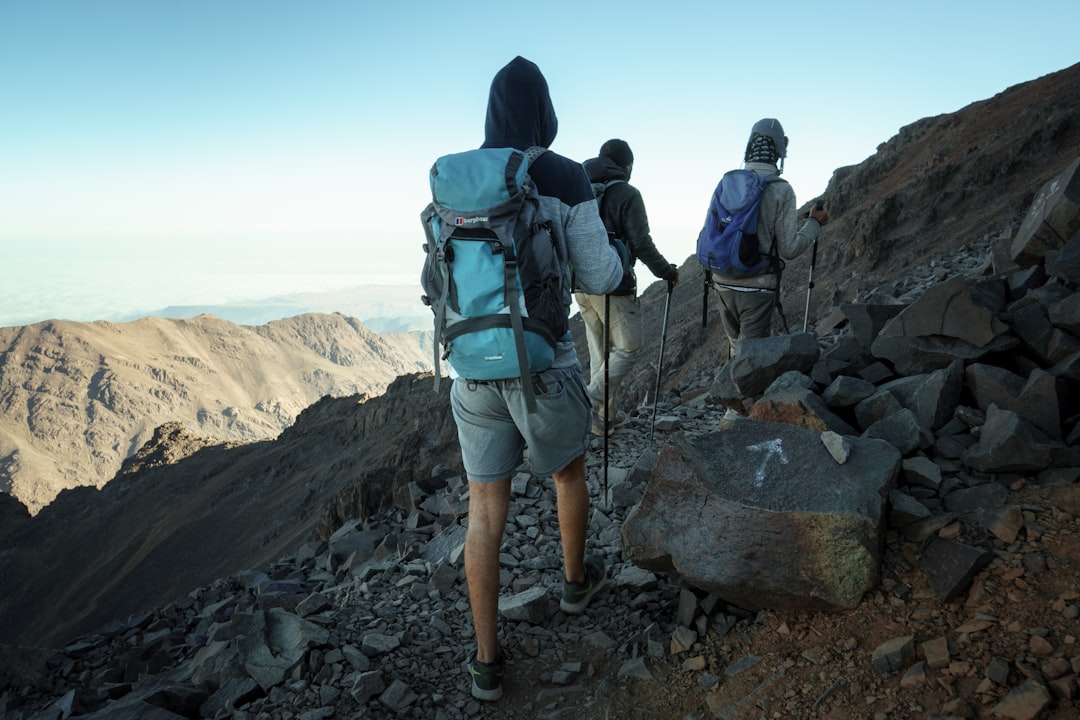 A guide leads a group of travelers along a rocky trail above one of Morocco's most remote Moroccan mountain villages.