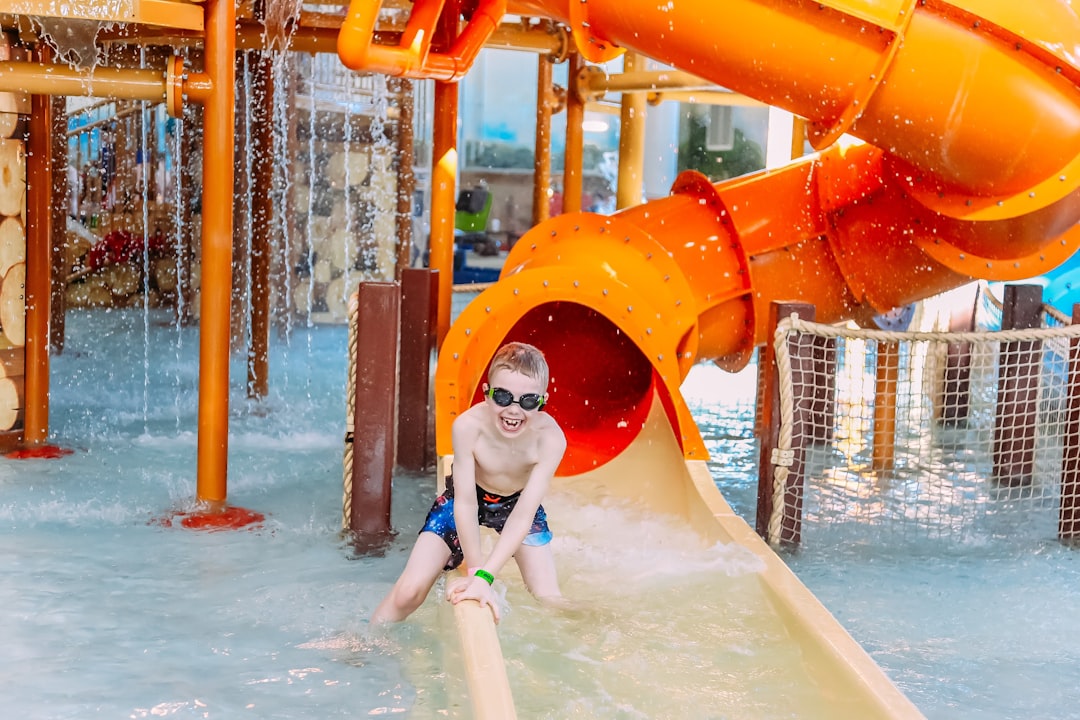 Children enjoying water slides together, keeping kids cool at an outdoor water park on a hot Moroccan summer day.