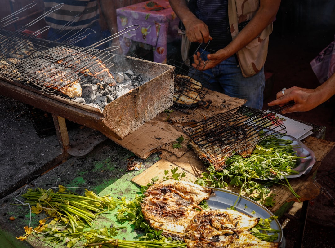 A vendor grilling fresh brochettes at a Moroccan market, showing the heat preparation that makes street food safer in summer