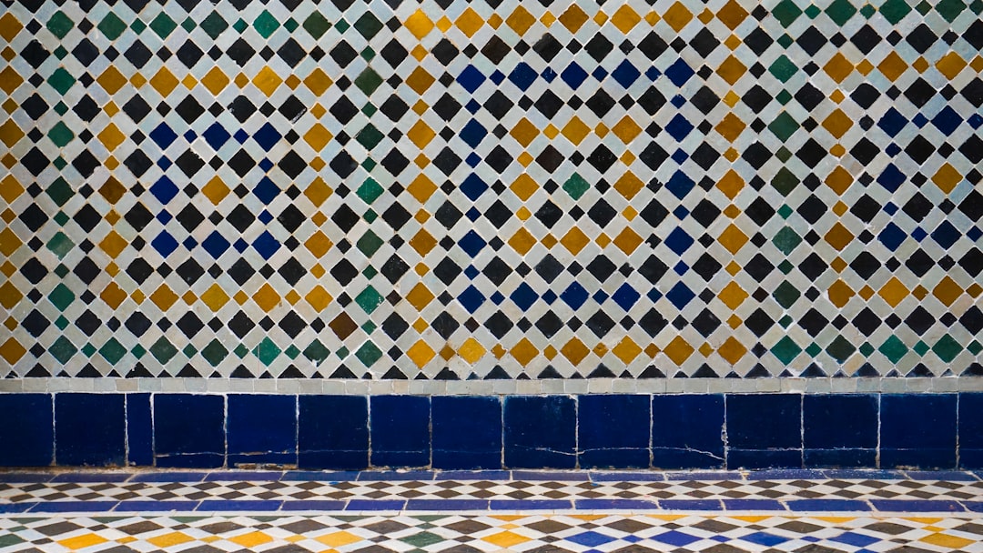 An interior designer presenting a modern kitchen featuring a deep-blue zellige tilework backsplash