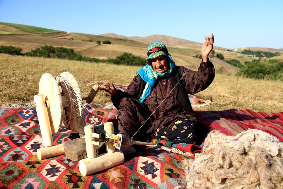 A Moroccan artisan works at a traditional loom, creating handwoven textiles in rich natural colors in a cooperative workshop.