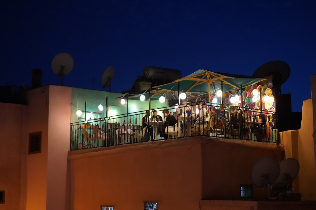enjoying cocktails on one of the rooftop terraces in Marrakech, with the Koutoubia Mosque in the background at sunset.