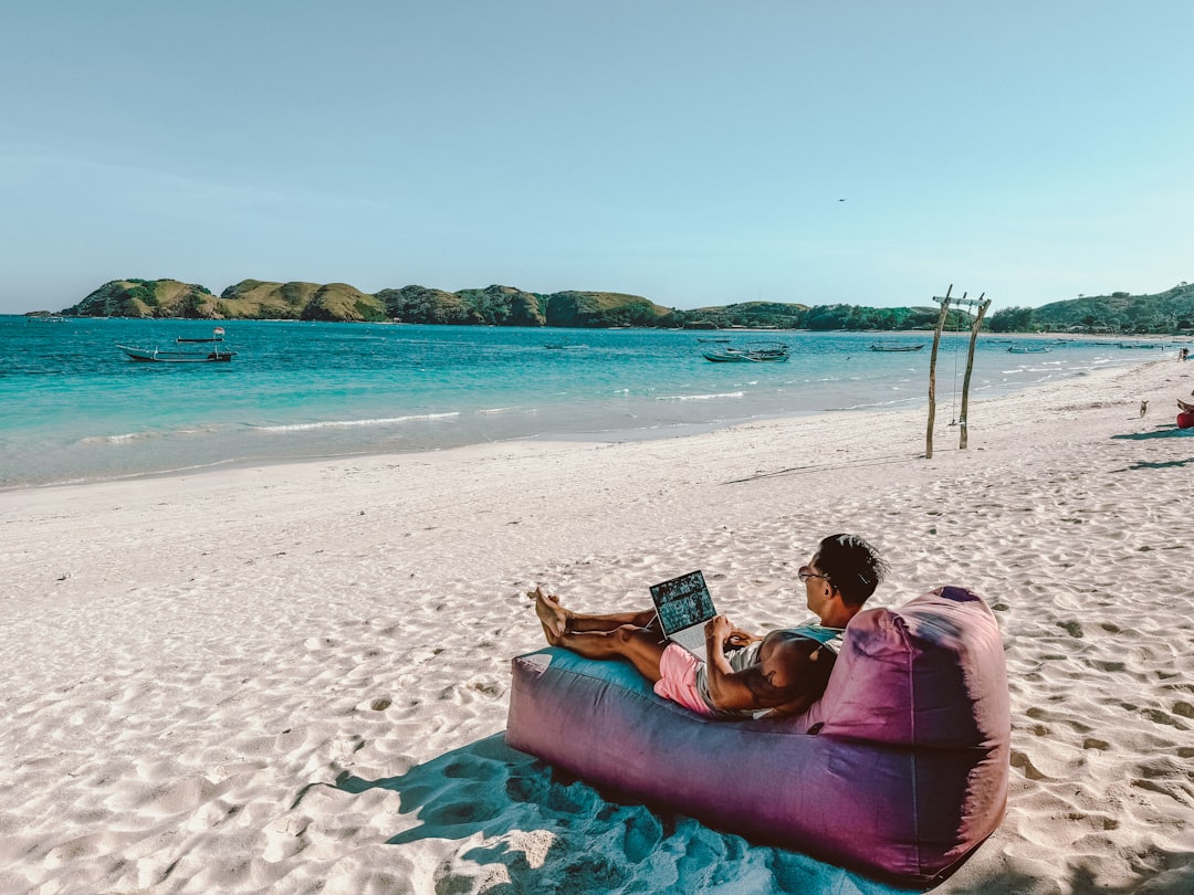 A digital nomad working on a laptop at a coworking space on Morocco's Atlantic coast with ocean views in the background
