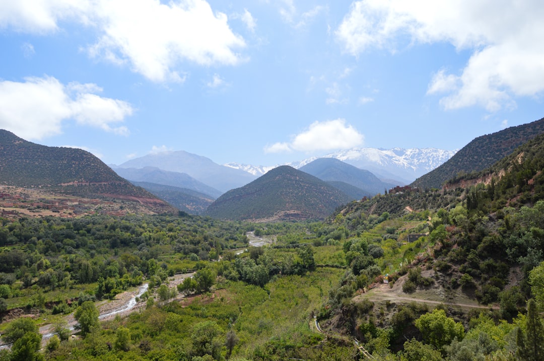 Two hikers approach the Ouzoud waterfalls along a mountain trail near Azilal in Morocco's central High Atlas