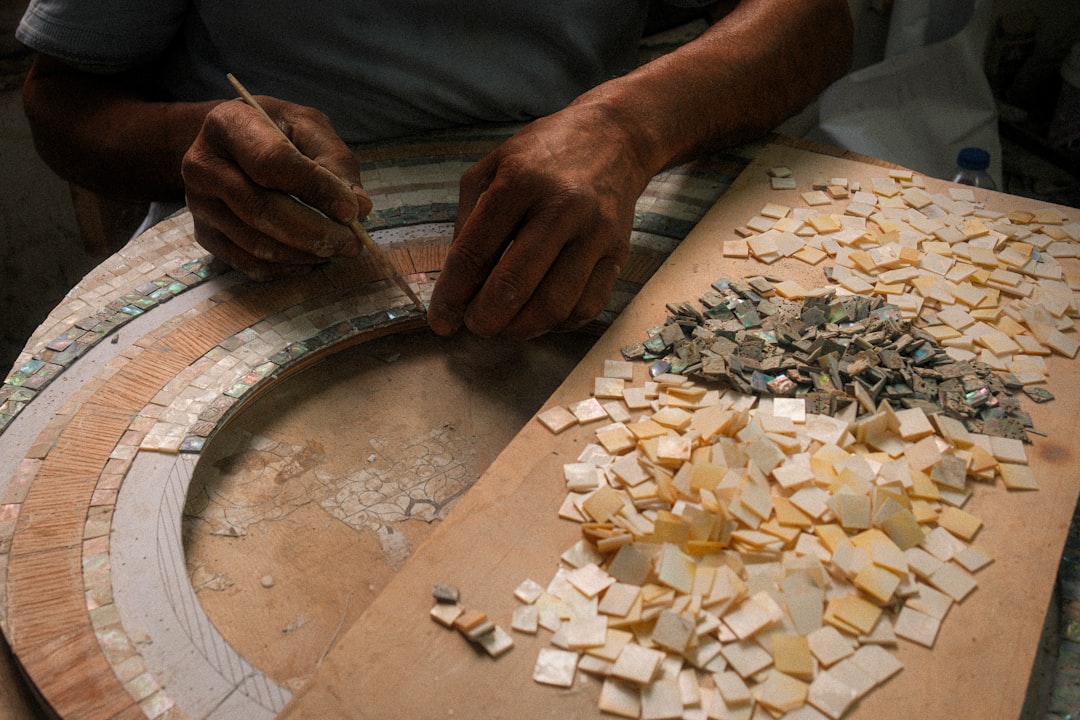 A maallem master artisan cuts hand-shaped zellige pieces in a traditional Moroccan mosaic workshop in Fez