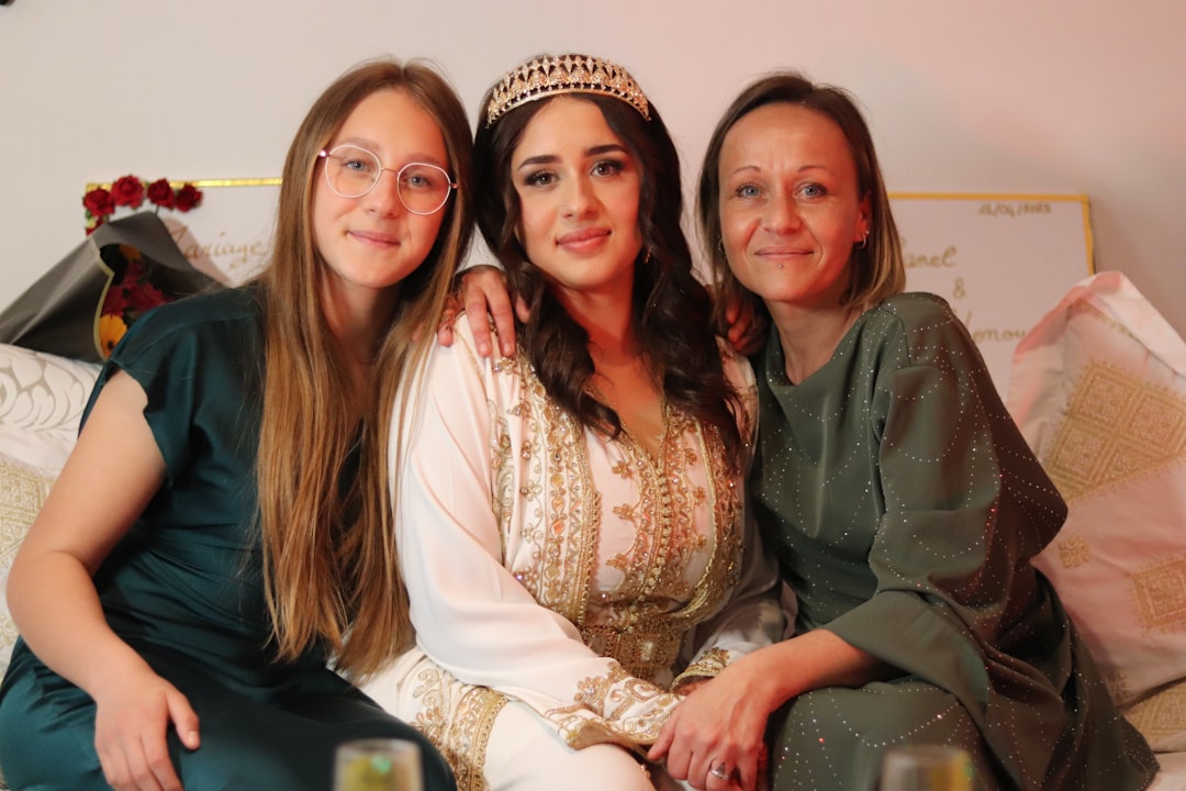 A Moroccan family dressed in traditional djellabas gathering outdoors during Fête du Trône festivities in a city medina