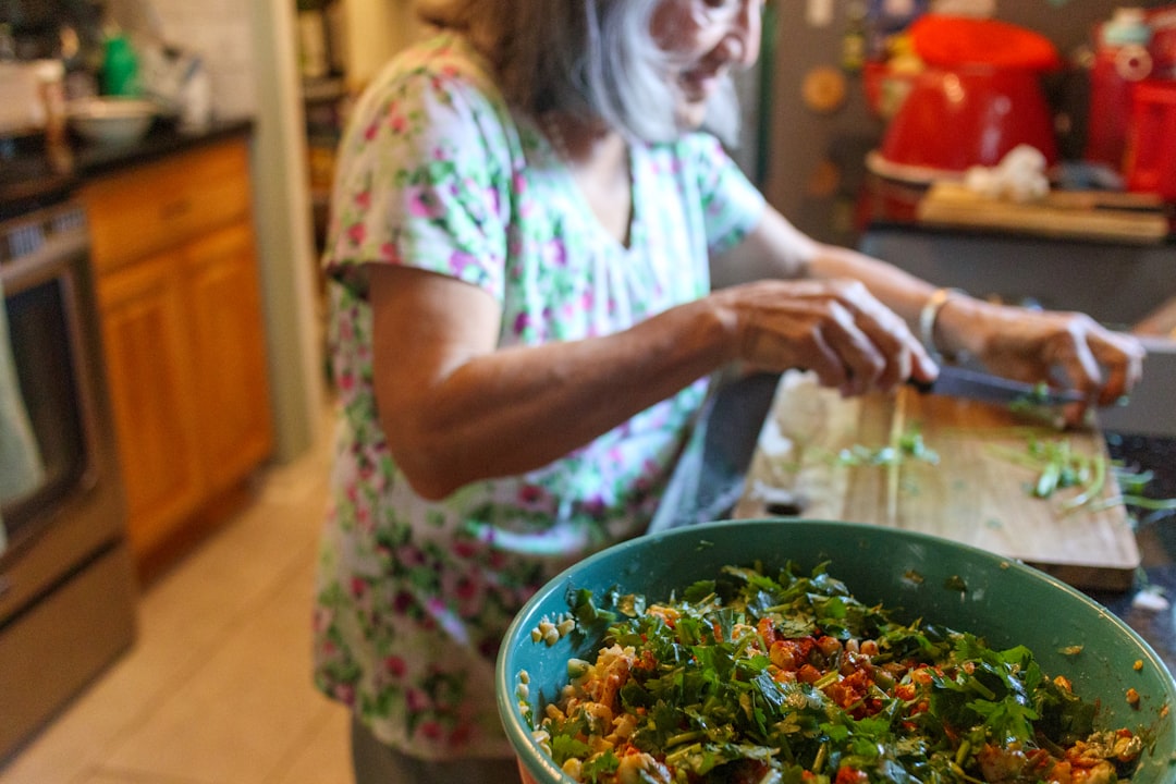 A Moroccan woman preparing a fresh zaalouk salad at home, showing how summer cooking in Morocco