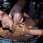 A mother and child shape clay together during a Morocco holiday craft workshop in a traditional Fes pottery studio