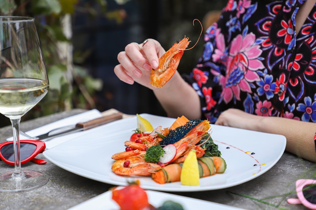 A woman enjoys naturally gluten-free Moroccan street food brochettes at a charcoal grill stall in a busy medina.
