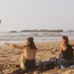 People enjoying the beach along Essaouira’s Atlantic coast in Morocco, with ocean waves and a scenic coastal atmosphere