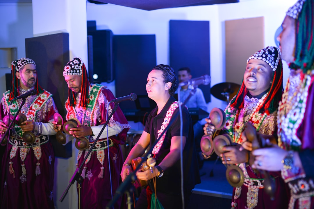 A Gnawa musician performing for a neighbourhood crowd during Throne Day celebrations in a Moroccan medina