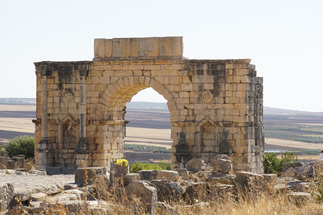 A man standing among the Roman ruins of Volubilis near Meknes, a key stop on any imperial cities Morocco route