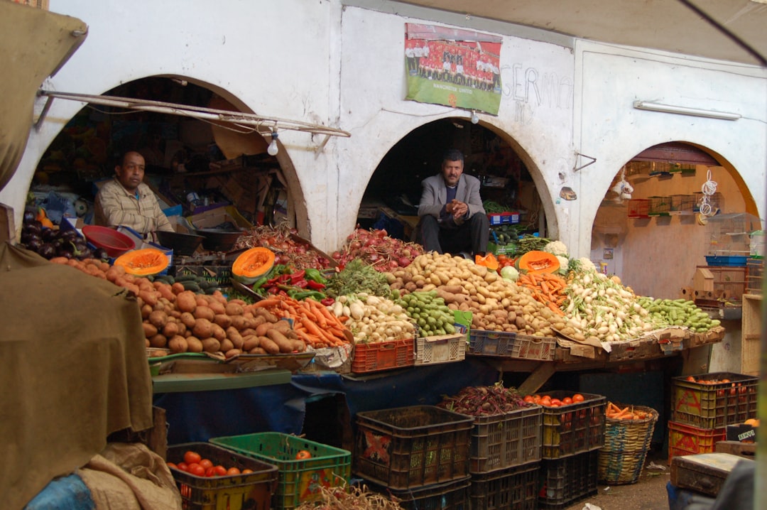 A man browsing fresh vegetables and olives at a Moroccan souk, ideal for gluten free eating at Morocco festivals