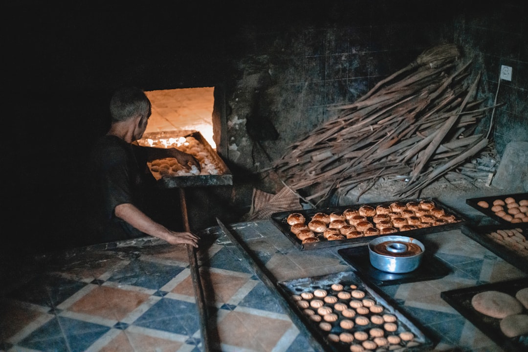 A baker arranging sesame and almond pastries made with souk ingredients on a traditional Moroccan tray