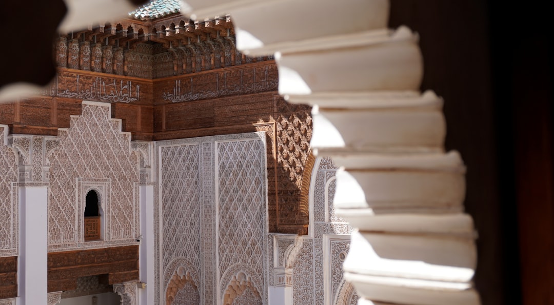 A Moroccan craftsman installing a wooden mashrabiya screen as part of a riad cooling and ventilation system