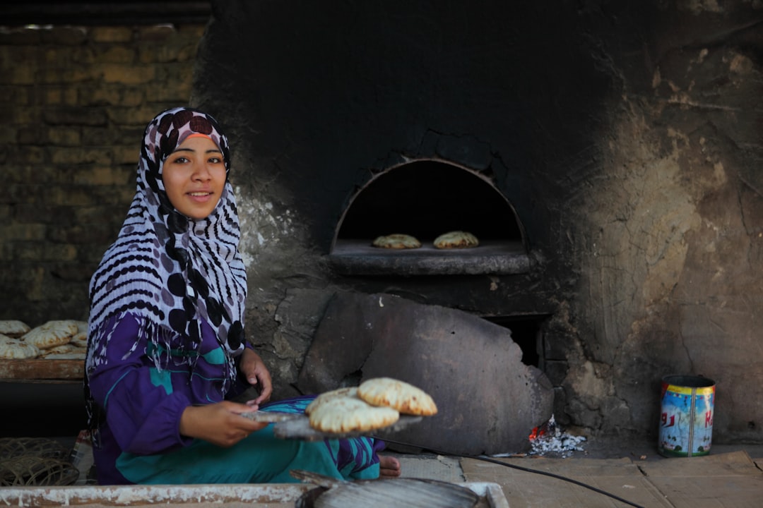 A Moroccan woman using traditional souk ingredients to prepare natural baking dough in a home kitchen