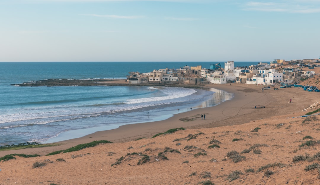A man prepares to enter a rocky cove for open water swimming on the clear Mediterranean coast of Morocco