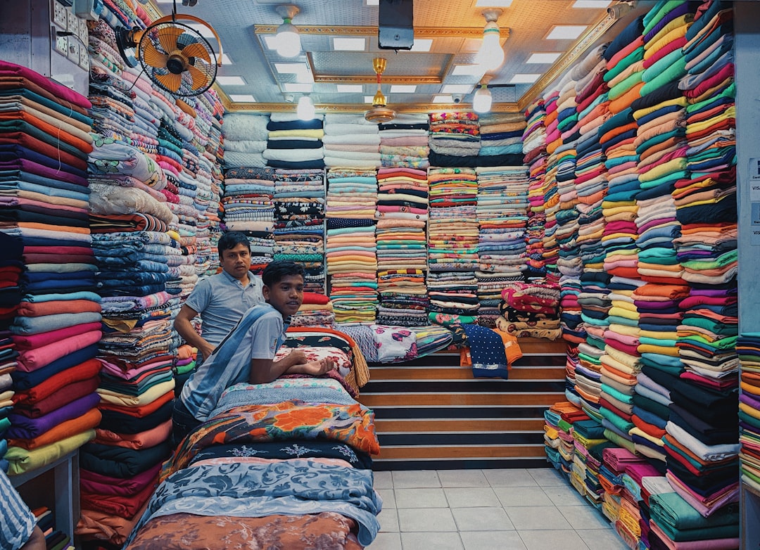 A person carefully inspects deadstock fabric rolls inside a Moroccan medina souk