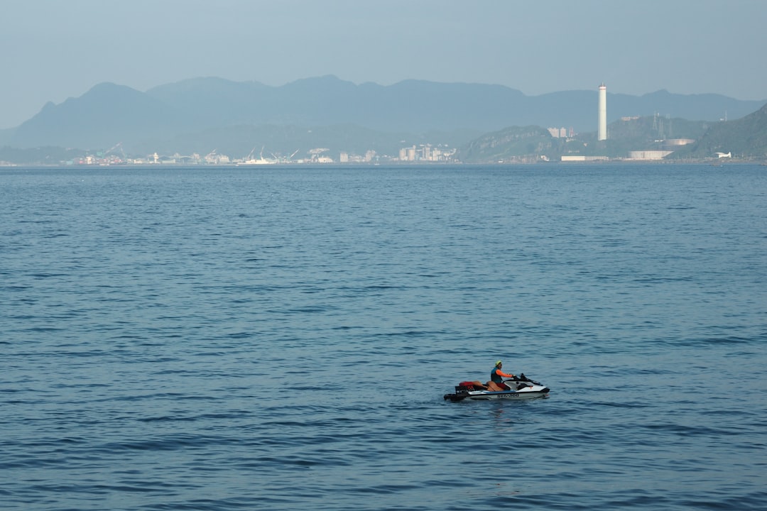 A swimmer with a tow float rests in calm open water on Morocco's sunny Mediterranean coast in late August
