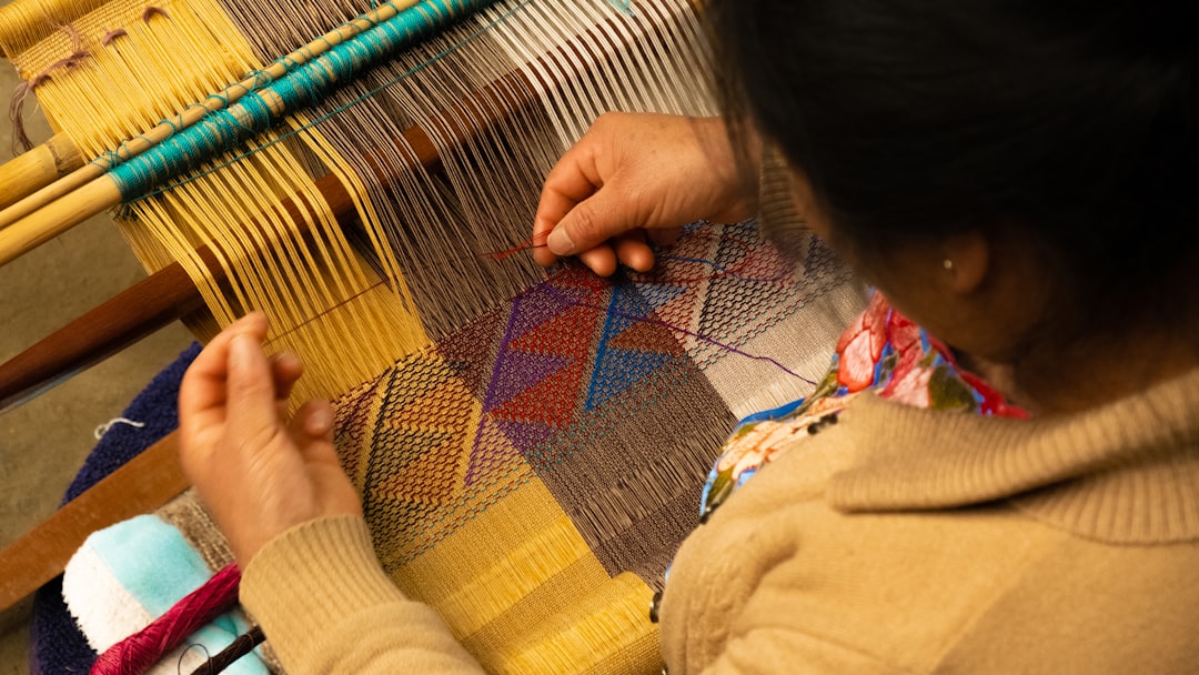 A woman artisan works with surplus deadstock fabric on a traditional loom in Fès
