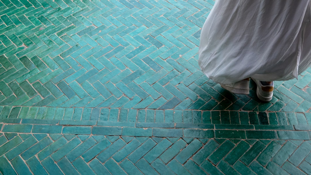 A woman walking barefoot on a zellige tile floor, enjoying the natural riad cooling effect of Moroccan materials