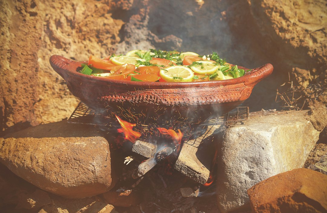A Moroccan home cook adds seasonal vegetables to a clay tajine, a staple of autumn cooking in Moroccan households