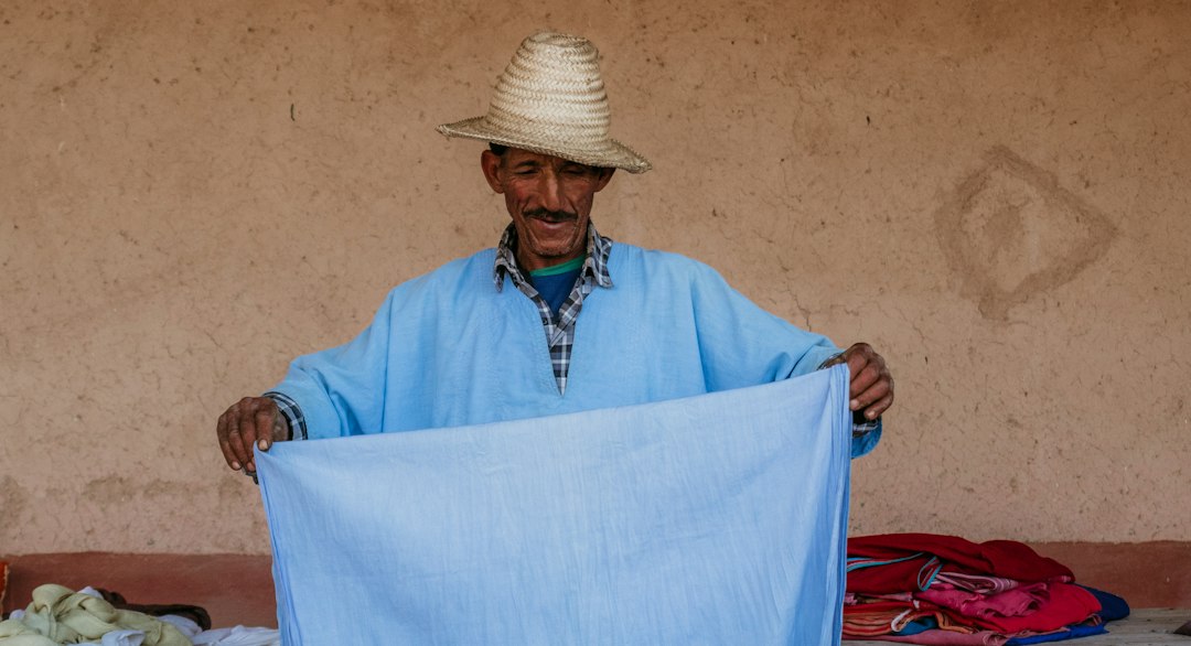 A Moroccan artisan weaving fabric inside a cooperative, showing the process behind building a capsule wardrobe