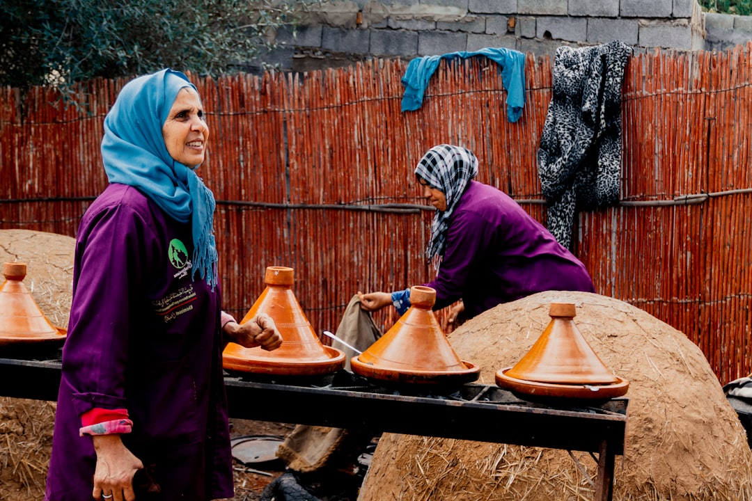 A Moroccan woman carefully preparing a traditional tagine, representing the depth of Moroccan food culture passed down.