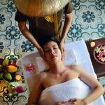 A woman receiving a traditional hammam reset treatment with black soap and a kessa glove in a Moroccan bathhouse