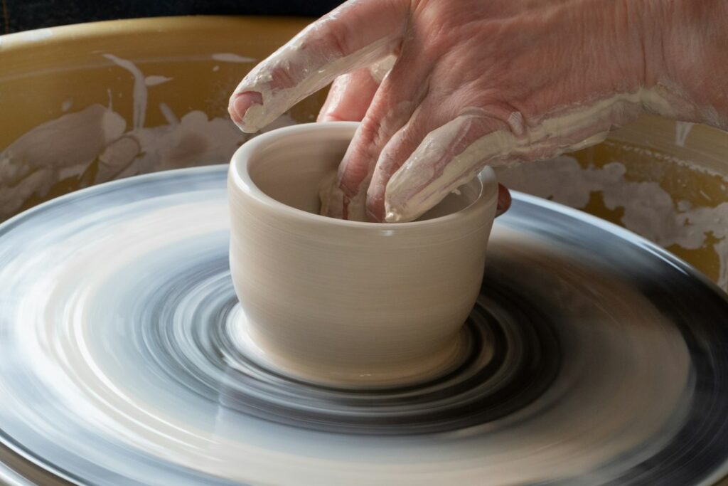 Beginner practicing a pottery hobby on a wheel in a Moroccan studio