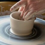 Beginner practicing a pottery hobby on a wheel in a Moroccan studio